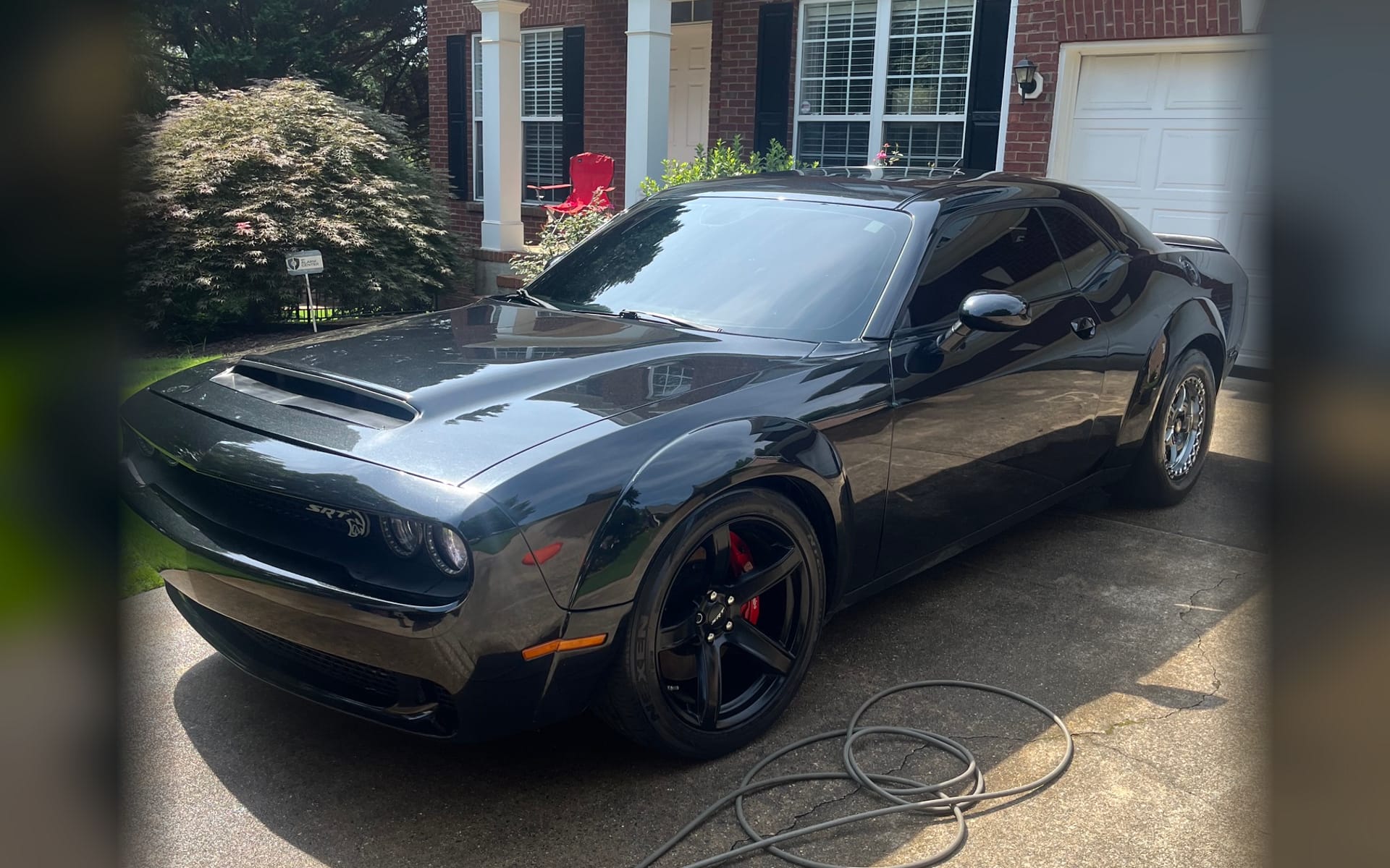 A black Dodge Challenger SRT detailed in a north Atlanta driveway by Peachtree Mobile Detail